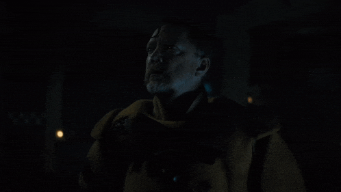 a man in a dark room with the words " what have you done " below him