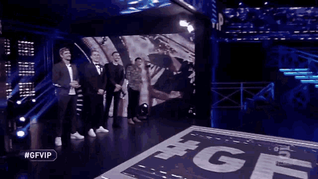 a group of men are standing in front of a screen that says #gfvip on it