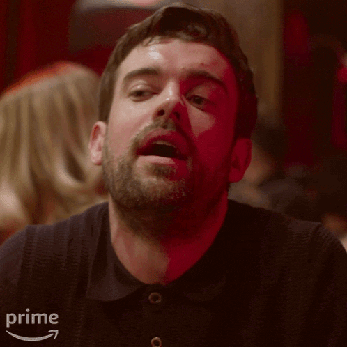 a man with a beard is smiling and looking at the camera .