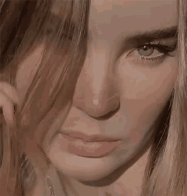 a close up of a woman 's face with a necklace around her neck