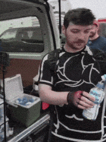 a man is holding a bottle of airbus water in his hand