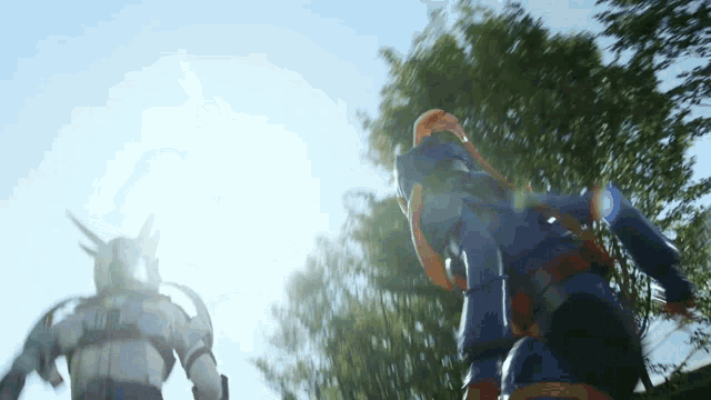 two robots are standing next to each other with the sun shining through the trees in the background