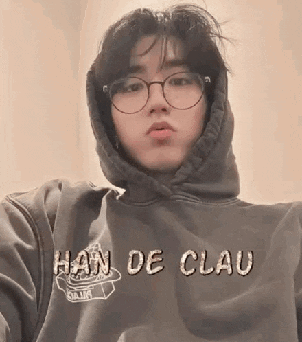 a man wearing a hoodie and glasses is taking a selfie .
