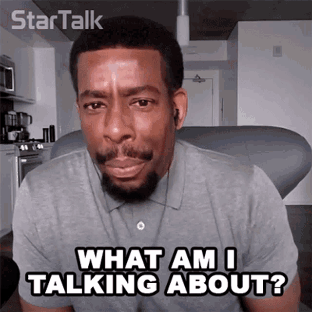 a man with a beard is sitting on a couch and says what am i talking about
