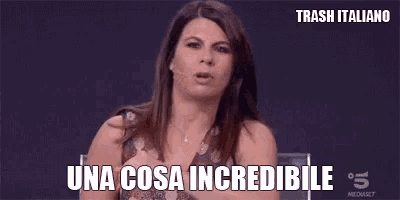 a woman is making a funny face and pointing at her chest with the words `` una cosa incredibile '' .