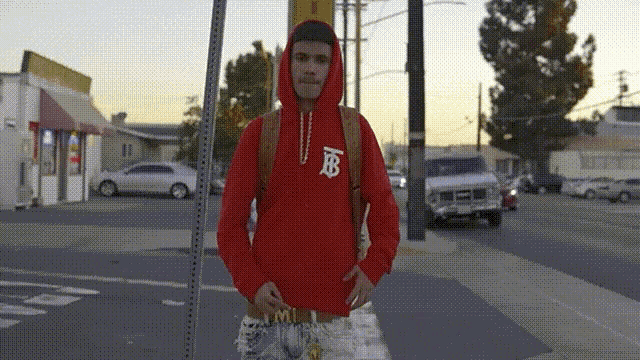a man in a red hoodie with the letter b on the front