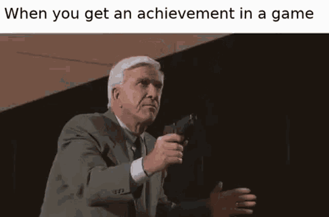 a man in a suit and tie is pointing a gun at a flame coming out of it .