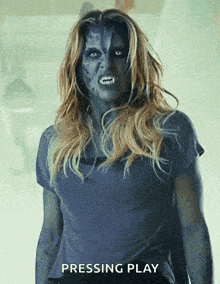 a woman with blue paint on her face is standing in front of a sign that says " pressing play "