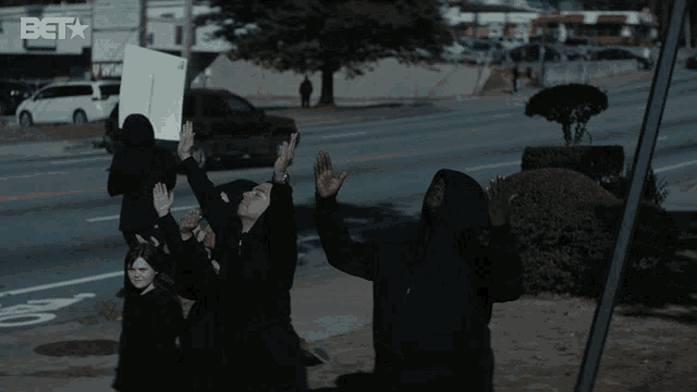 a group of people holding up a sign that says bet