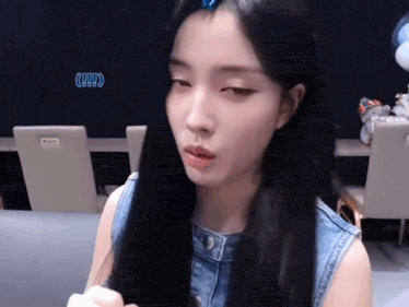 a woman with long black hair has a blue clip in her hair that says 9999