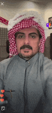 a man with a beard and mustache wearing a head scarf and a grey shirt