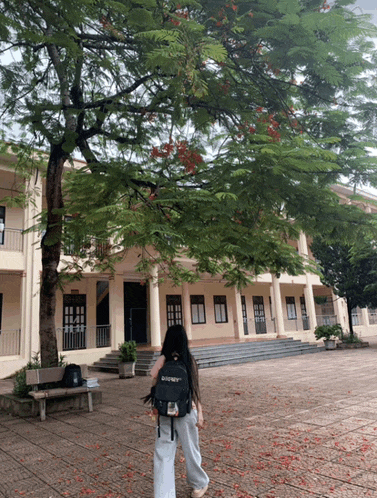 a girl walking in front of a building with a backpack that says disney