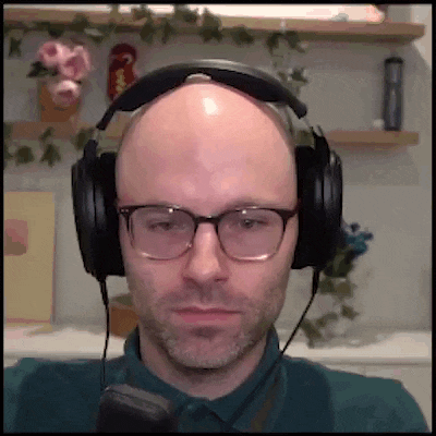 a bald man wearing glasses and headphones is making a funny face .