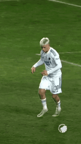 a soccer player with the number 30 on his jersey is running on the field