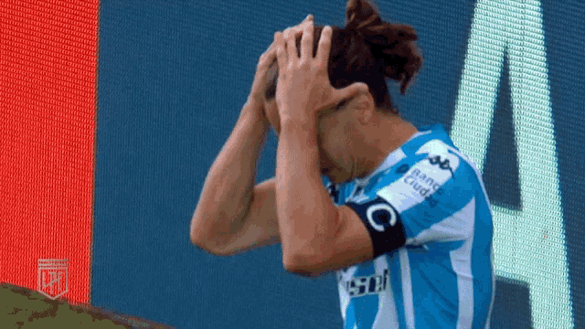 a soccer player wearing a blue jersey with the letter c on the armband