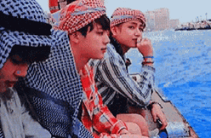 a group of men are sitting on a boat in the water .