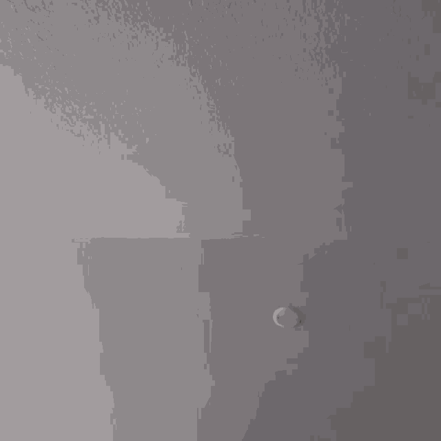 a ceiling fan is spinning on a gray ceiling in a room .
