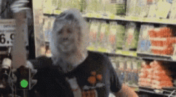 a man is standing in a grocery store with a plastic bag over his head .