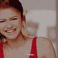a woman in a red top is smiling and saying thanks .
