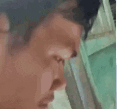 a close up of a man 's face with a yellow badge on his neck .