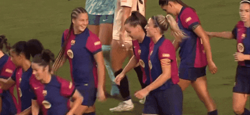 a group of female soccer players are running on the field .