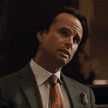 a man in a suit and tie is looking at something