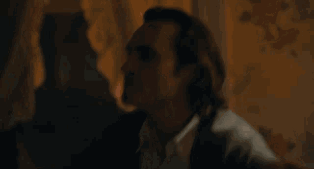 a close up of a man 's face with a woman touching his hair .