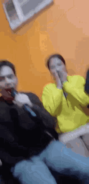 a man and a woman are singing into microphones .