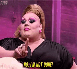 a drag queen is pointing at the camera and saying no , i 'm not done !
