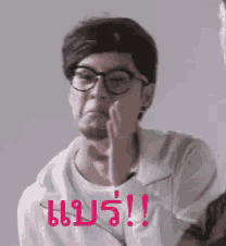 a man wearing glasses and a white shirt is making a funny face with his hand .