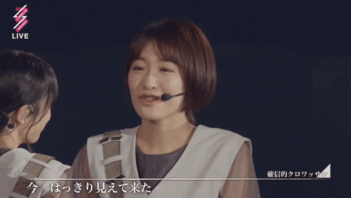 a girl with a microphone making a heart with her hands and the word live in the corner
