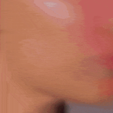 a close up of a woman 's face with dreadlocks and a tattoo on her chest