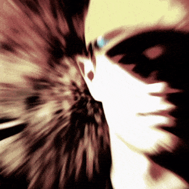 a blurred image of a person 's face with a swirl in the background