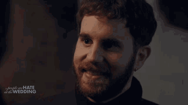 a close up of a man 's face with the words people we hate at the wedding behind him