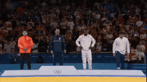 three athletes stand on a podium with the olympics logo on it