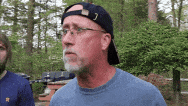 a man wearing glasses and a hat with the letter c on it