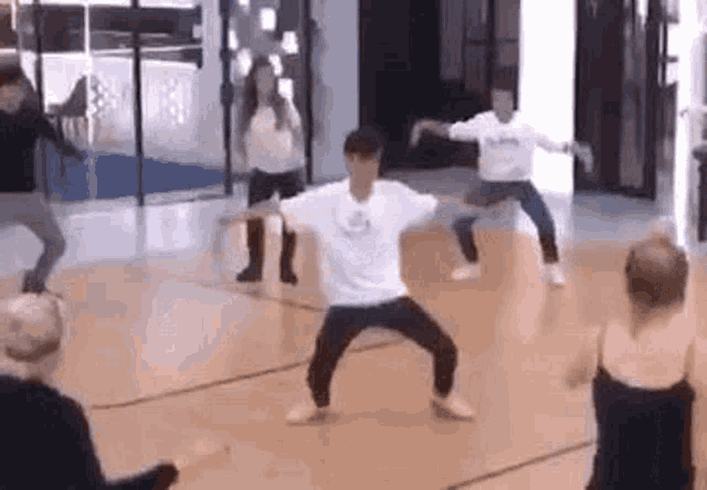 a group of people are dancing on a dance floor in a studio .