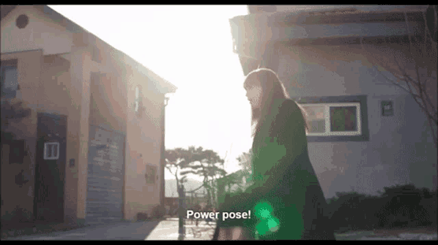 a woman standing in front of a building with the words power pose written on the bottom