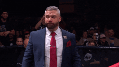 a man in a suit and tie stands in front of a crowd that says security