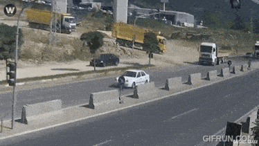 a gif from gifrun.com shows a car driving down a street