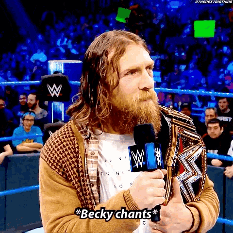 a man with a beard is holding a wrestling trophy and says becky chants