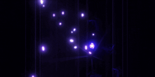 a purple light beam is coming out of a dark background