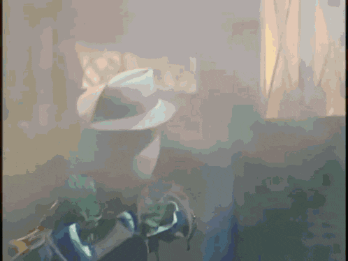 a blurred image of a person wearing a hat and sunglasses