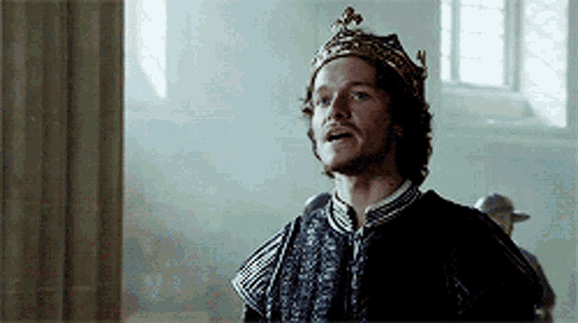 a man wearing a crown and a black coat