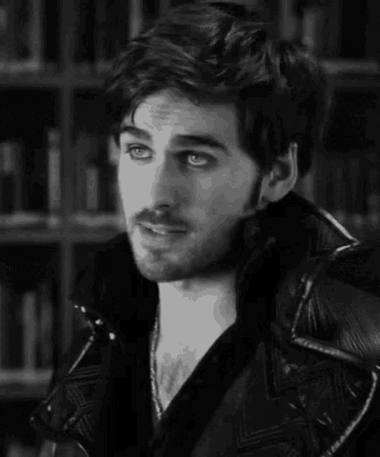 a black and white photo of a smiling man with a beard