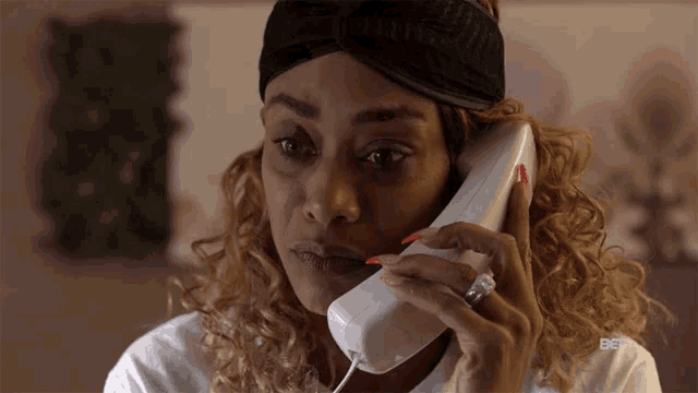 a woman talking on a phone with bet written on the bottom of her shirt