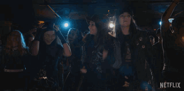 a group of people are dancing in a dark room with a netflix logo in the corner