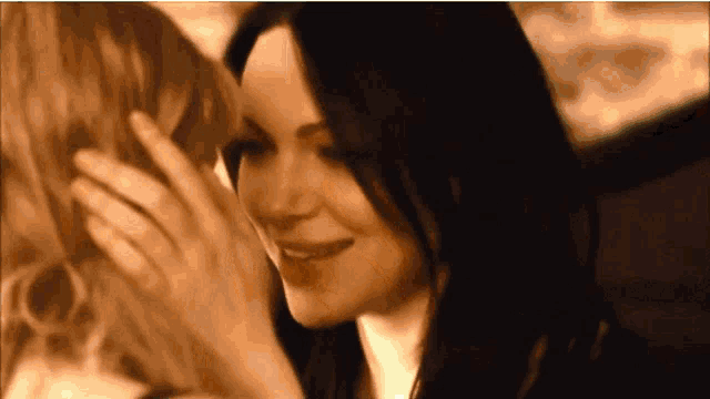 a woman is touching another woman 's face with her hand