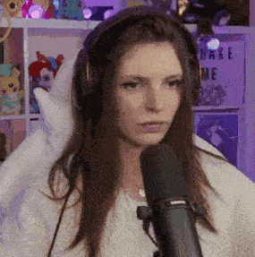 a woman wearing headphones is sitting in front of a microphone in a room .