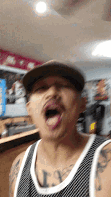 a man wearing a hat and a tank top has a tattoo on his chest that says 19